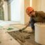 Artisan posant du carrelage lors d'une étape de rénovation intérieure